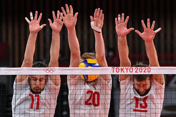 Фабиан Држизга, Матеуш Бениек и Михал Кубяк из Польши пытаются заблокировать удар во время Олимпийских игр -  2020. - Sputnik Молдова