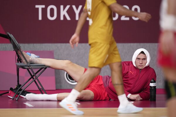 Датчанин Лассе Андерссон наблюдает за игрой после травмы во время гандбольного матча на летних Олимпийских играх - 2020. - Sputnik Молдова
