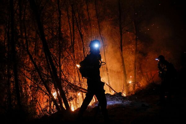 Силуэт пожарного, который борется с огнем у деревни Зирия, недалеко от Патр, Греция, 1 августа 2021 года. - Sputnik Молдова