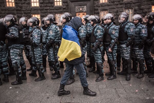 Сторонник евроинтеграции Украины и сотрудники милиции у здания правительства страны в Киеве - Sputnik Молдова