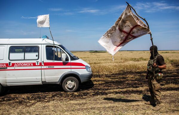 Украинский военный с белым флагом во время передачи убитых на нейтральной территории вблизи поселка Диброво в Донецкой области - Sputnik Молдова