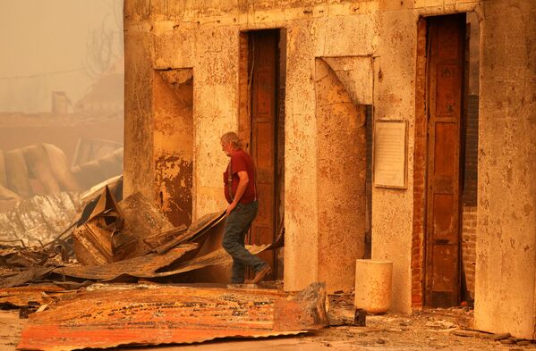 Localnicul Woody Hovland inspectează o clădire comercială distrusă în urma incendiului Dixie, un incendiu care a afectat grav orașul Greenville, California, SUA, 5 august 2021. - Sputnik Moldova-România