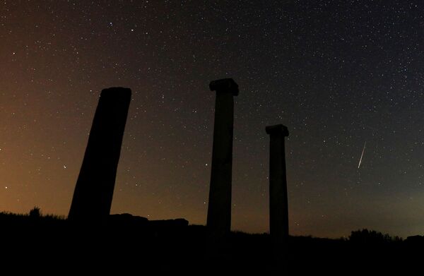 În fotografia cu expunere lungă se văd stele și meteori deasupra coloanelor orașului antic Stobi, în apropiere de Stipa, Macedonia de Nord, 12 august 2021.. - Sputnik Moldova