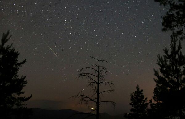 Un meteor străbate cerul deasupra Muntelui Tvrtkovac în timpul curentului de meteori Perseide, vedere din Zenica, Bosnia și Herțegovina, 8 august 2021. - Sputnik Moldova
