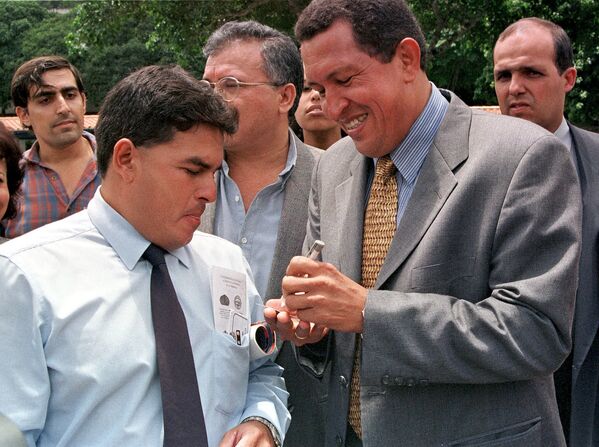Кандидат в президенты Венесуэлы Уго Чавес Фриас дает автограф своему стороннику 24 сентября в Каракасе по прибытии в Университет Симона Боливара. - Sputnik Молдова