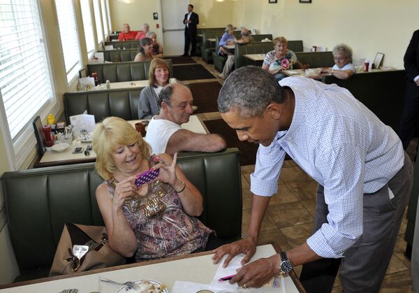 Президент США Барак Обама дает автограф во время обеда в местном ресторане в Леноксе, штат Пенсильвания. - Sputnik Молдова