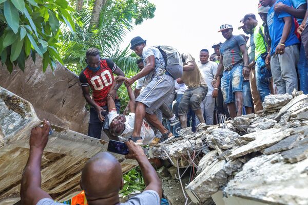 IMAGINE NERECOMANDABILĂ PENTRU CEI CU SLABI DE SPIRITOamenii recuperează corpul politicianului Jean Gabriel Fortune din dărâmăturile unui hotel în urma cutremurului cu magnitudinea 7,2 din Les Cayes, Haiti, 14 august 2021. - Sputnik Moldova