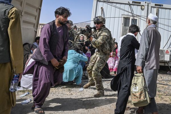 Солдат США направляет оружие в сторону афганского пассажира в кабульском аэропорту. - Sputnik Молдова