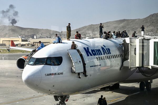 Afganii urcă în vârful unui avion pe aeroportul din Kabul pe 16 august 2021, după un final uimitor de rapid al războiului de 20 de ani din Afganistan. Mii de oameni au dat năvală în aeroportul orașului încercând să fugă, temându-se de Taliban. - Sputnik Moldova-România