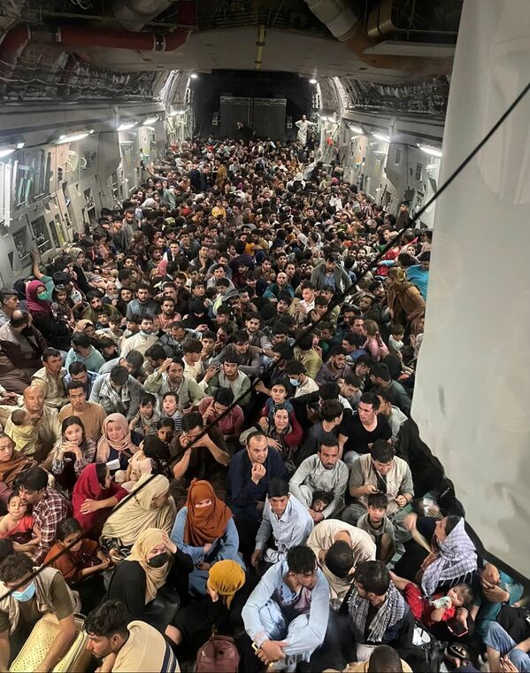 O mulțime de persoane evacuate se înghesuie într-un avion de transport C-17 Globemaster III al Forțelor Aeriene ale SUA, care transportă aproximativ 640 de afgani în Qatar din Kabul, Afganistan 15 august 2021. Imagine din 15 august 2021. - Sputnik Moldova-România