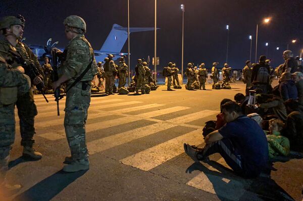 Французские солдаты стоят на страже, пока граждане Франции и их афганские коллеги ждут, чтобы сесть в военно-транспортный самолет в аэропорту Кабула для эвакуации из Афганистана после военного захвата страны талибами. - Sputnik Молдова