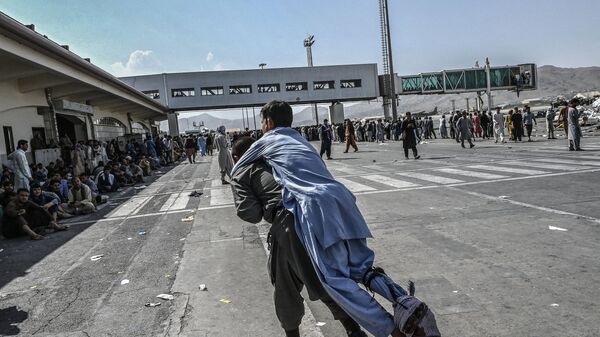 Волонтер с раненым афганцем в аэропорту Кабула  - Sputnik Молдова