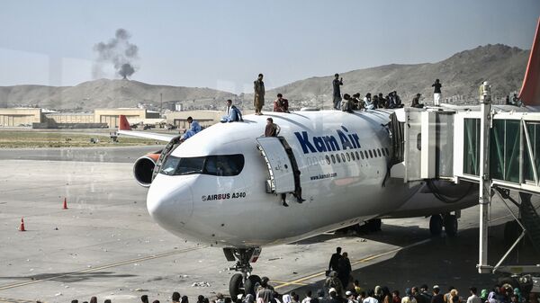Афганцы забираются на самолет в аэропорту после вступления талибов в Кабул - Sputnik Moldova-România
