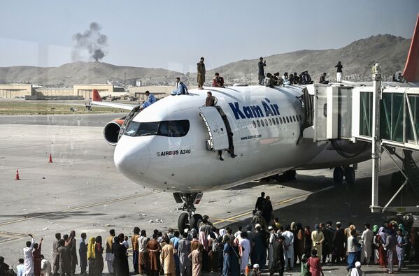 Афганцы забираются на самолет в аэропорту после вступления талибов в Кабул. - Sputnik Молдова