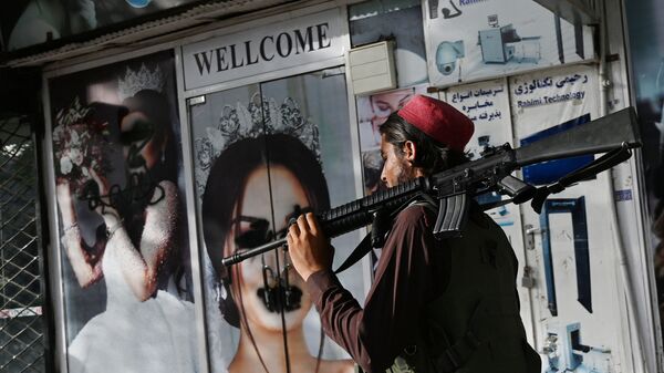 Боевик Талибана* у салона красоты с изображениями женщин, испачканных аэрозольной краской, в Шахр-э Нау в Кабуле - Sputnik Moldova-România