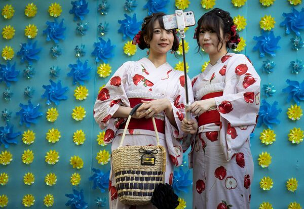 Женщины в кимоно позируют для селфи в храме Сэнсо-дзи в Токио, Япония. - Sputnik Молдова