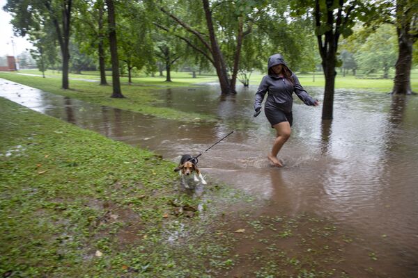 Девушка с собакой на затопленной улице после тропического шторма &quot;Генри&quot; в США. - Sputnik Молдова
