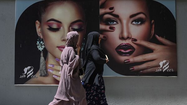 Женщины в парандже проходят мимо рекламного щита на стене салона красоты в Кабуле - Sputnik Moldova-România