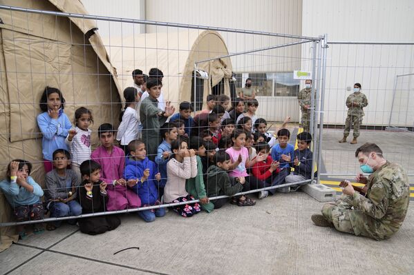 На фото – американский солдат с авиабазы Рамштайн играет на укулеле для детей, эвакуированных из Афганистана в Германию. - Sputnik Молдова