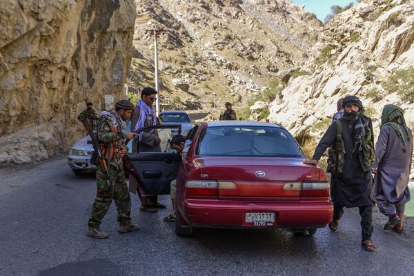 Mișcarea de rezistență afgană și forțele de revoltă anti-talibane verifică trecerea vehiculelor în timp ce sunt desfășurate pentru a patrula de-a lungul unui drum la Rah-e Tang din provincia Panjshir la 25 august 2021, după preluarea militară a talibanilor în Afganistan. - Sputnik Moldova-România
