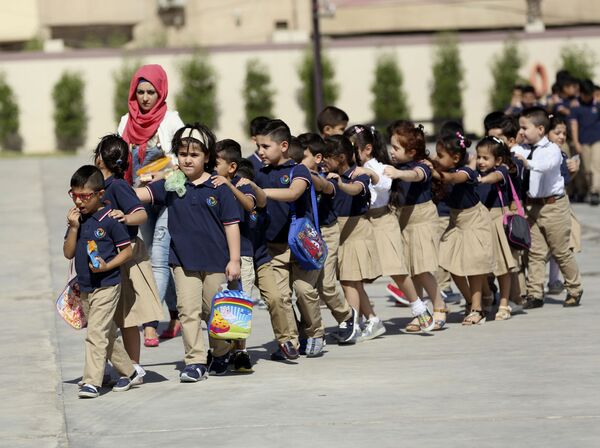 Elevi în uniforme, încolonați în prima zi de școală într-o instituție de învățământ din Baghdad, Iraq. - Sputnik Moldova