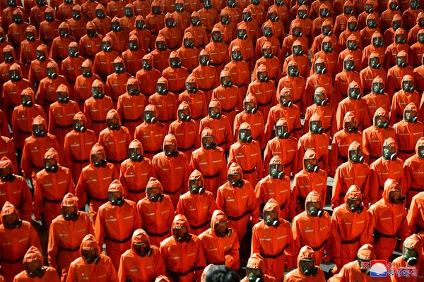 Personalul îmbrăcat în costume de portocaliu portocaliu marșează în timpul unei defilări paramilitare organizată pentru a marca cea de-a 73-a aniversare fondatoare a republicii în piața Kim Il Sung din Phenian - Sputnik Moldova-România