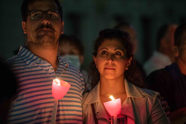 Пара держит свечи на религиозной церемонии в память об 11 сентября в Греческой православной национальной святыне Святого Николая. - Sputnik Молдова