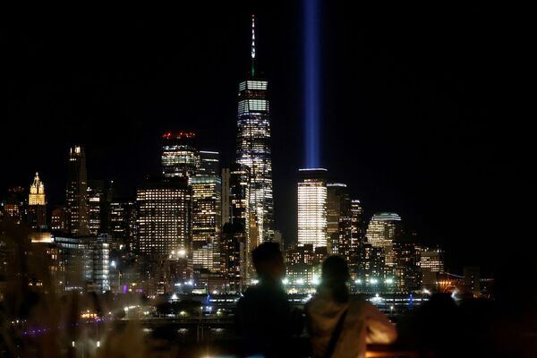 Un cuplu privește coloanele  de lumină ale instalație Tribute in Light și turnul One World Trade Center din parcul Little Island, în ajunul împlinirii a 20 de ani de la atacurile din 11 septembrie din Manhattan, New York, SUA, 10 septembrie 2021. - Sputnik Moldova