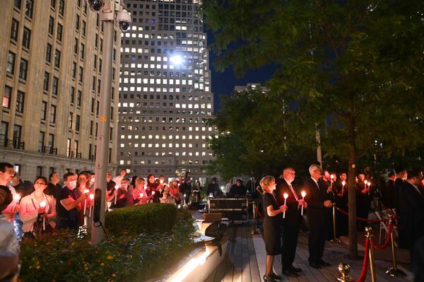 Oameni cu lumânări aprinse în timpul ceremoniei religioase de comemorare la Altarul Național Ortodox Grec Sfântul Nicolae, lângă Memorialului și Muzeului 9/11 din New York, 10 septembrie 2021. - Sputnik Moldova