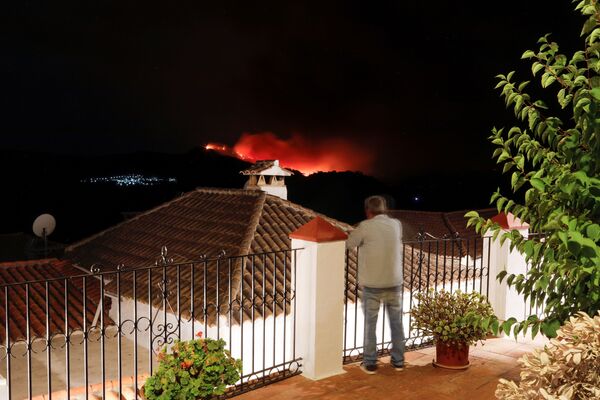 Un bărbat privește de pe balcon incendiul din apropierea orașului Pujerra, care a fost evactuat, în Cartajima, în apropiere de Estepona, Spania, 12 septembrie 2021. - Sputnik Moldova-România