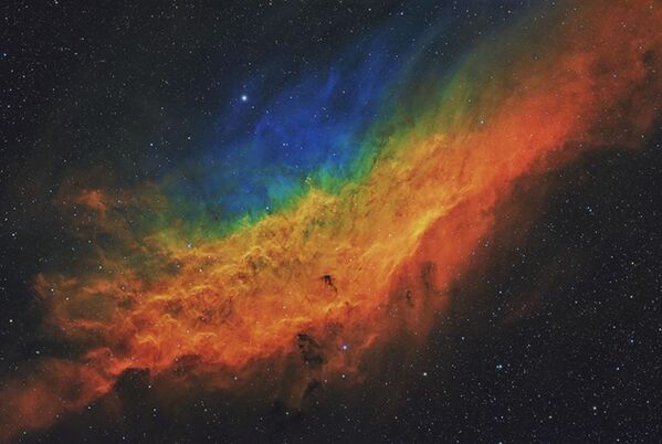 Туманность Калифорния, также известная как NGC 1499, была запечатлена в течение семи ночей в 2021 году с использованием широкополосных и узкополосных фильтров с общим временем интеграции 16,1 часа. Эта эмиссионная туманность имеет длину около 100 световых лет и находится на расстоянии 1000 световых лет от Земли. Она названа туманностью Калифорния, потому что напоминает очертания американского штата Калифорния. Уайтуотер, Колорадо, США, 16–31 января, 6 и 28 февраля, 2 марта 2021 г. - Sputnik Молдова