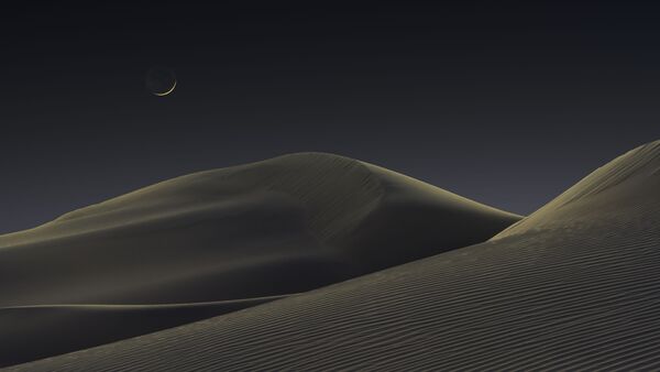 Тлеющий полумесяц плывет в синей океанской атмосфере над тихими светящимися песчаными дюнами, а красный закат перешел в синие сумерки. Национальный парк Долина Смерти, Калифорния, США, 25 февраля 2020 года. - Sputnik Молдова