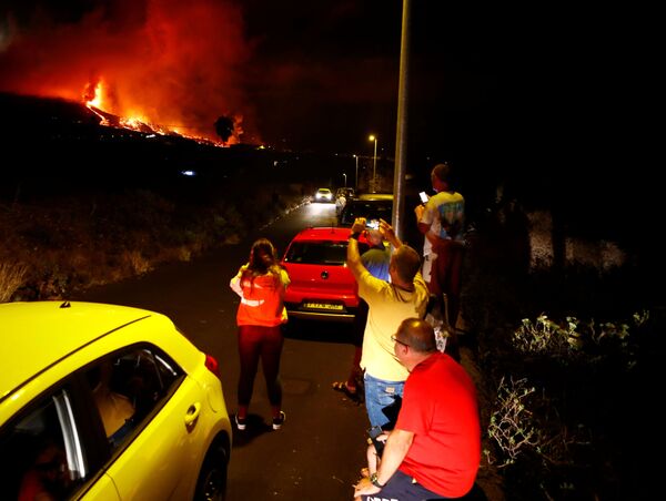 Locuitorii privesc lava în urma erupției unui vulcan în parcul național Cumbre Vieja de la El Paso, pe Insula Canare La Palma, 19 septembrie 2021. Imagini făcute 19 septembrie 2021. - Sputnik Moldova-România