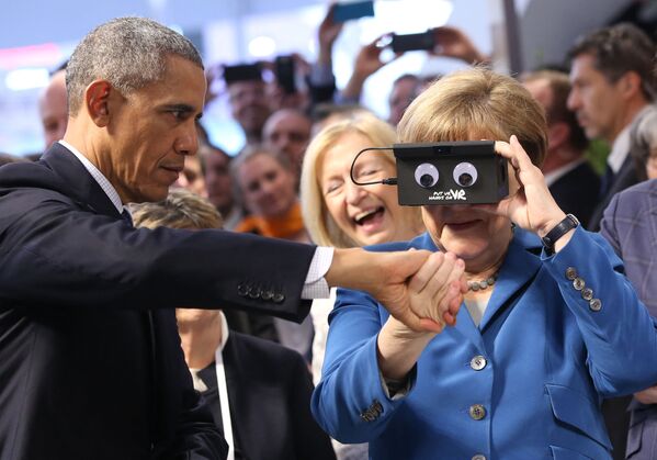 Cancelarul german Angela Merkel se uită printr-un dispozitiv de lângă președintele american Barack Obama (L) la standul companiei germane de automatizare ifm electronic în timp ce vizitează târgul industrial Hanovra din Hanovra, Germania centrală, pe 25 aprilie 2016. - SUA este țara parteneră al târgului industrial Hannover Messe 2016 care se desfășoară în perioada 25 aprilie - 29 aprilie 2016. - Sputnik Moldova-România