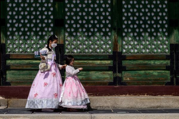 Vizitatorii poartă rochie tradițională hanbok la Palatul Gyeongbokgung din Seul pe 20 septembrie 2021, cu o zi înainte de sărbătoarea Chuseok. - Sputnik Moldova-România