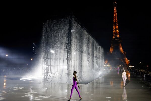 Un model prezintă o creație a designerului Anthony Vaccarello ca parte a expoziției sale de colecții de îmbrăcăminte pentru femei din primăvara / vara 2022 pentru casa de modă Saint Laurent, în fața Turnului Eiffel în timpul Săptămânii modei din Paris, la Paris, Franța, 28 septembrie, 2021. - Sputnik Moldova-România