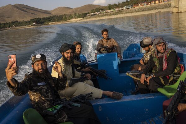 Luptătorii talibani se bucură de o plimbare cu barca în barajul Qargha, la periferia Kabul, Afganistan, vineri, 24 septembrie 2021. - Sputnik Moldova-România