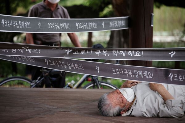 Un bărbat se odihnește la un pavilion care a fost înconjurat ca o măsură pentru a evita răspândirea bolii coronavirusului (COVID-19) într-un parc din Seul, Coreea de Sud, 27 septembrie 2021 - Sputnik Moldova-România