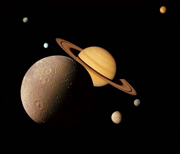 Этот коллаж изображений от Сатурна от НАСА был подготовлен из нескольких фотографий, сделанных космическим кораблем &quot;Вояджер-1&quot; во время его встречи с Сатурном в ноябре 1980 года. На этом снимке видна Диона на переднем плане, Сатурн, восходящий позади, Тетис и Мимас и Рея от колец Сатурна слева, а Титан на своей далекой орбите вверху. - Sputnik Молдова