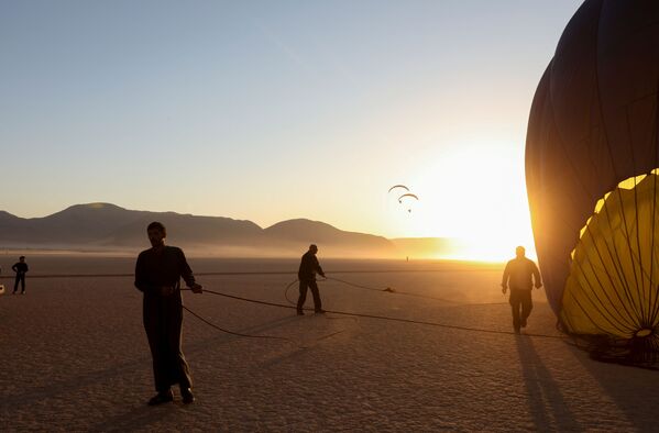 Bărbații pregătesc balonul înainte de decolare în timpul festivalului baloanelor cu aer cald din deșertul Wadi Rum, Iordania, 1 octombrie 2021. - Sputnik Moldova