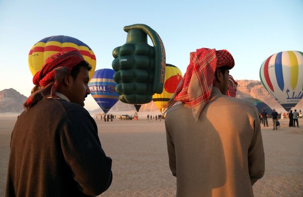 Bărbații privesc cum sunt pregătite baloanele înainte de decolare în timpul festivalului baloanelor cu aer cald din deșertul Wadi Rum, Iordania. - Sputnik Moldova