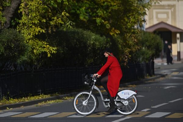 O tânără pe bicicleta lângă mănăstirea Novodevicie din Moscova. - Sputnik Moldova