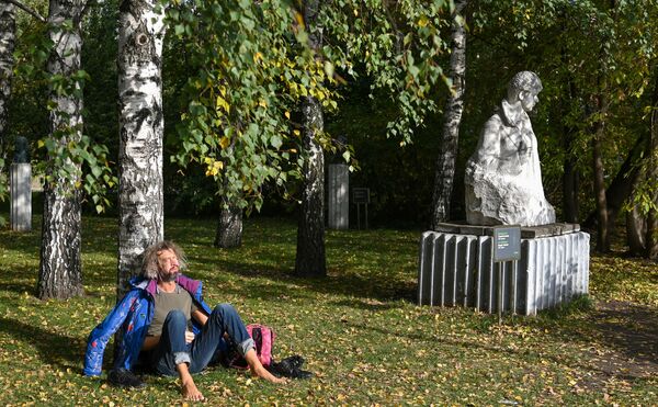 Un bărbat stă la soare sub un abrore în parcul de arte Muzeion. În dreapta - monumentul lui Serghei Esenin (sculptorul A. A. Biciukov) - Sputnik Moldova-România