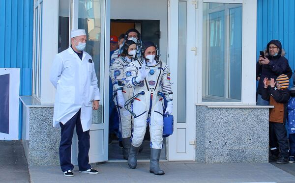 На этой фотографии, сделанной 5 октября 2021 года Роскосмосом, показаны члены экипажа, космонавт Антон Шкаплеров (первый), актриса Юлия Пересильд (вторая) и кинорежиссер Клим Шипенко, идущие на борт космического корабля Союз МС-19 перед его полетом - Sputnik Молдова