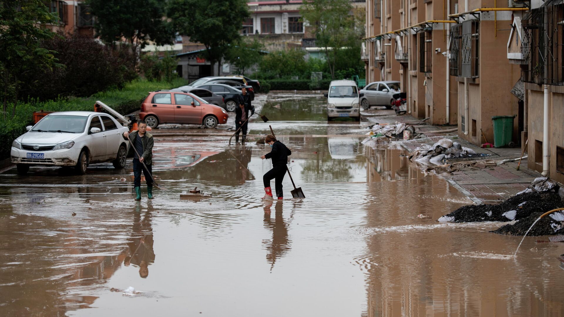 Жители расчищают двор жилого дома после проливных дождей в провинции Шаньси, Китай - Sputnik Молдова, 1920, 12.10.2021