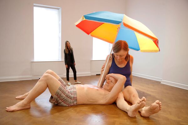 O angajată a galeriei pozează lângă o sculptură intitulată „Cuplul sub o umbrelă” a artistului australian Ron Mueck, expusă la galeria Thaddaeus Ropac din Londra, Marea Britanie, 11 octombrie 2021 - Sputnik Moldova