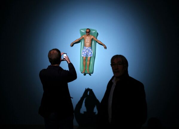 Un vizitator fotografiază „Drift”, o sculptură a artistului australian Ron Mueck expusă la Fondation Cartier pour l&#x27;art contemporain, pe 15 aprilie 2013 la Paris - Sputnik Moldova