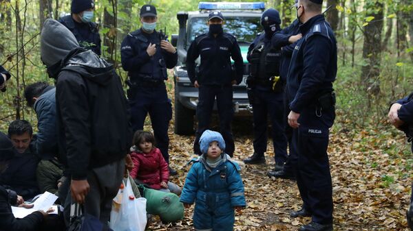 Мигранты в окружении пограничников и полицейских после того, как они пересекли белорусско-польскую границу, Хайновка, Польша - Sputnik Moldova-România