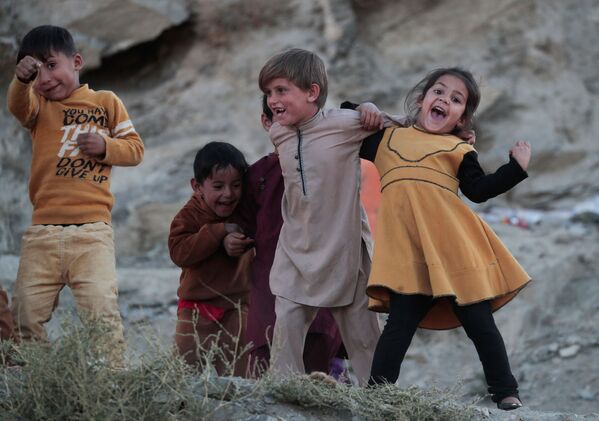 Copiii se joacă în afara casei lor pe muntele TV din Kabul, Afganistan, 15 octombrie 2021. - Sputnik Moldova-România