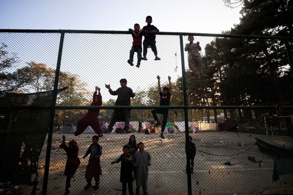 Copii afgani, strămutați cu familiile lor care fug de violența din provincia lor, urcă un gard în parcul Shahr-e Naw, din Kabul, Afganistan, 14 octombrie 2021. - Sputnik Moldova-România